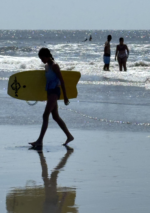Little girl carrying a bodyboard at Folly Beach